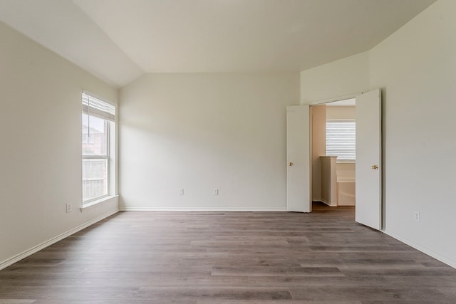 1720 Triumph Trl, Arlington, TX 76002 - spare room featuring wood finished floors, lofted ceiling, and baseboards