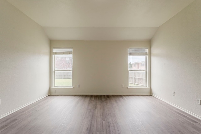 1720 Triumph Trl, Arlington, TX 76002 - spare room featuring wood finished floors, vaulted ceiling, baseboards, and a textured wall