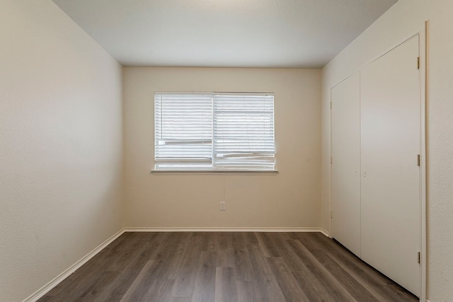 1720 Triumph Trl, Arlington, TX 76002 - unfurnished bedroom with wood finished floors, baseboards, and a closet
