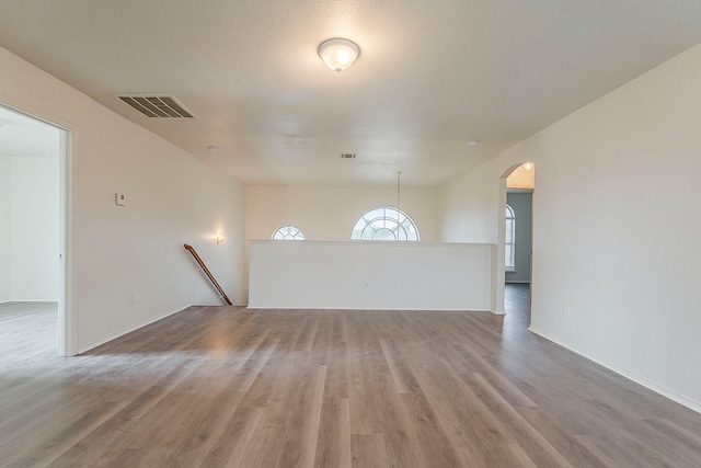 1720 Triumph Trl, Arlington, TX 76002 - unfurnished living room featuring arched walkways and wood finished floors