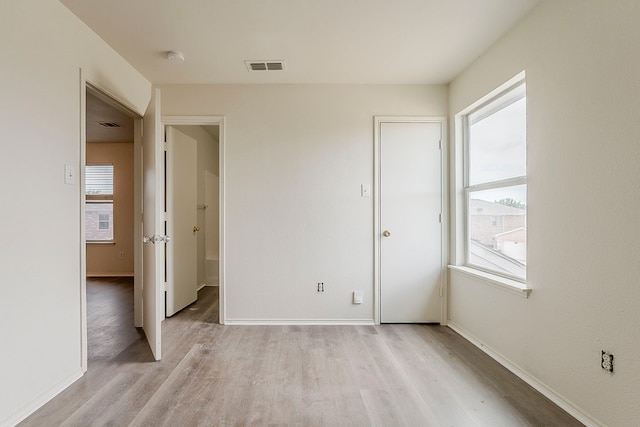 1720 Triumph Trl, Arlington, TX 76002 - unfurnished bedroom with multiple windows, light wood-style floors, and baseboards