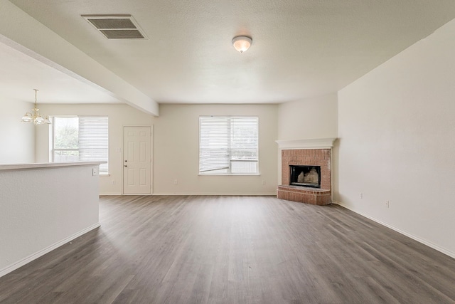 1720 Triumph Trl, Arlington, TX 76002 - unfurnished living room with dark wood-type flooring, a chandelier, a brick fireplace, baseboards, and beam ceiling
