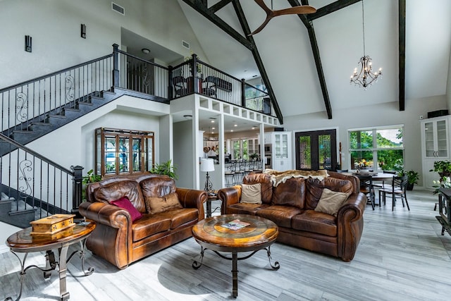 8799 County Road 299, Possum Kingdom Lake, TX 76450 - living room with high vaulted ceiling, a chandelier, stairway, wood finished floors, and beam ceiling