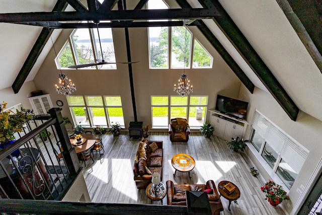 8799 County Road 299, Possum Kingdom Lake, TX 76450 - living area with a chandelier, high vaulted ceiling, a wood stove, beamed ceiling, and healthy amount of natural light