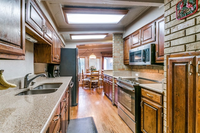 2412 Crestview Cir, Irving, TX 75062 - kitchen featuring appliances with stainless steel finishes, a sink, light wood-style flooring, tasteful backsplash, and light stone countertops