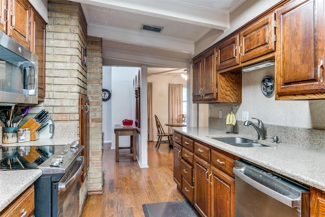 2412 Crestview Cir, Irving, TX 75062 - kitchen with stainless steel appliances, a sink, light wood-style flooring, ornamental molding, and light countertops