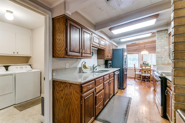 2412 Crestview Cir, Irving, TX 75062 - kitchen featuring washing machine and clothes dryer, appliances with stainless steel finishes, a sink, light countertops, and light wood finished floors