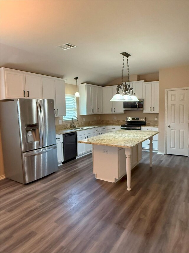 716 Riverhead Dr, Wylie, TX 75098 - kitchen featuring appliances with stainless steel finishes, a sink, white cabinets, dark wood-style flooring, and vaulted ceiling