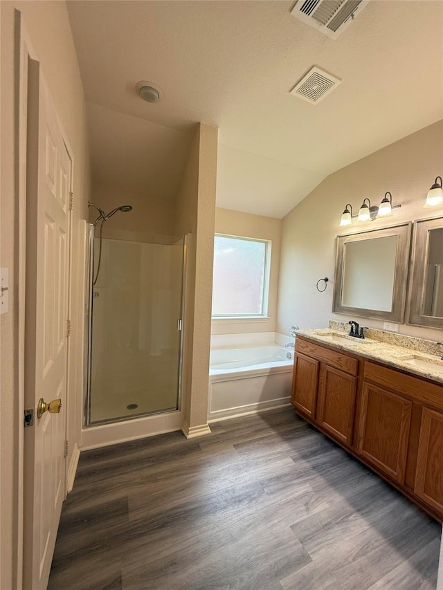 716 Riverhead Dr, Wylie, TX 75098 - full bathroom featuring lofted ceiling, a stall shower, a garden tub, wood finished floors, and double vanity