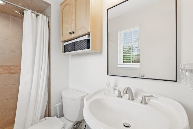 full bath with a sink, toilet, and a tile shower
