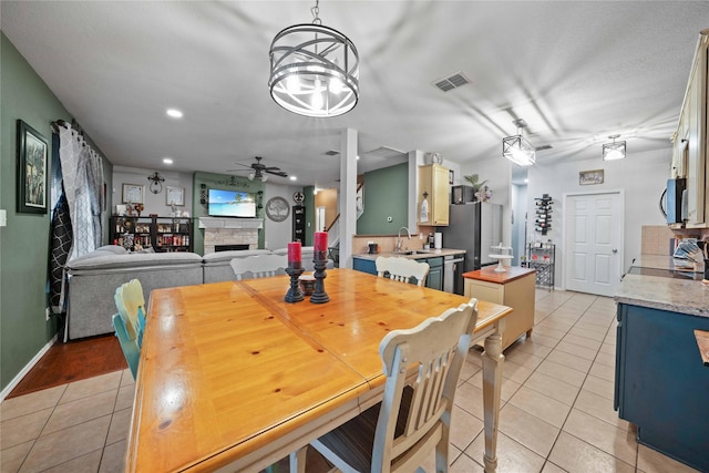 1412 Millbrook Ln, Wylie, TX 75098 - dining room with light tile patterned flooring, ceiling fan, a stone fireplace, recessed lighting, and baseboards