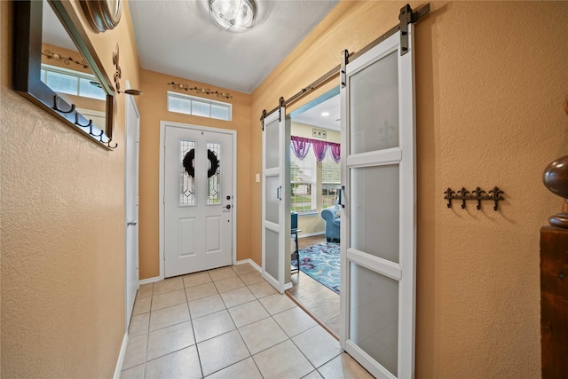 1412 Millbrook Ln, Wylie, TX 75098 - foyer entrance with a barn door, a textured wall, light tile patterned flooring, and baseboards