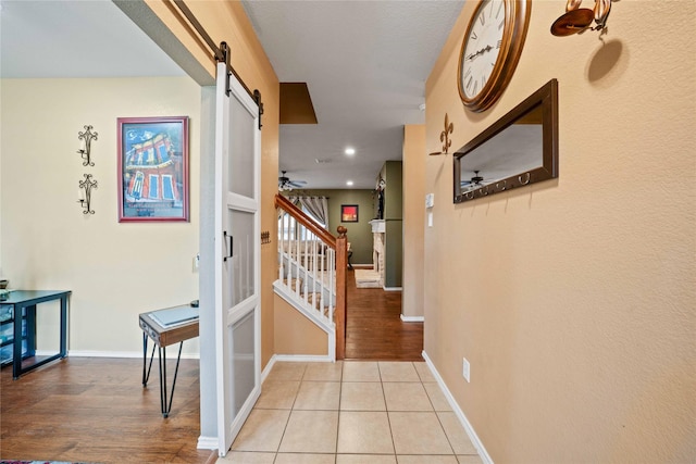 1412 Millbrook Ln, Wylie, TX 75098 - corridor with a barn door, stairs, baseboards, light tile patterned flooring, and recessed lighting
