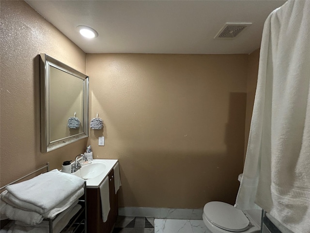 1209 E Tucker St, Fort Worth, TX 76104 - bathroom with marble look tiles, vanity, baseboards, and toilet