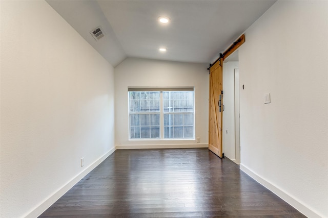 8919 San Fernando Way, Dallas, TX 75218 - empty room featuring a barn door, dark wood-style flooring, baseboards, lofted ceiling, and recessed lighting
