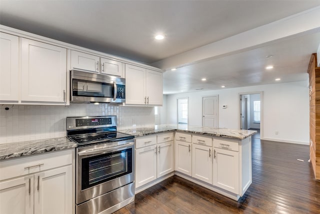 8919 San Fernando Way, Dallas, TX 75218 - kitchen featuring appliances with stainless steel finishes, a peninsula, backsplash, recessed lighting, and white cabinets