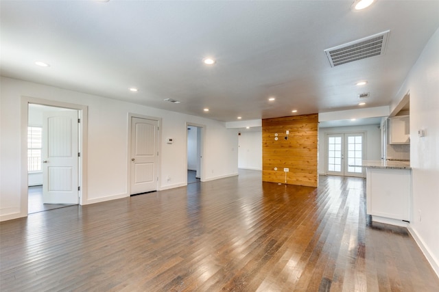 8919 San Fernando Way, Dallas, TX 75218 - unfurnished living room with dark wood-type flooring, recessed lighting, french doors, and baseboards