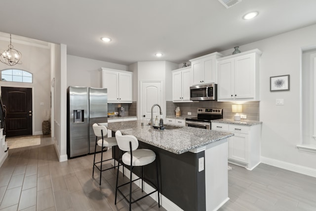 509 Oleander Dr, Royse City, TX 75189 - kitchen featuring appliances with stainless steel finishes, a sink, baseboards, a breakfast bar area, and an island with sink