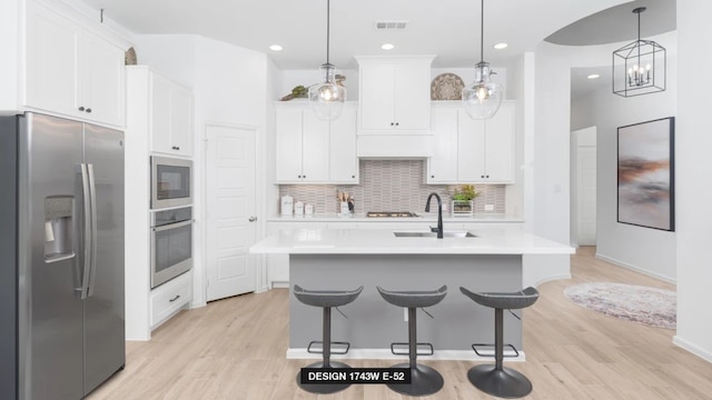 3501 Holly Hill Ln, Little Elm, TX 75068 - kitchen featuring appliances with stainless steel finishes, a sink, light countertops, backsplash, and white cabinets