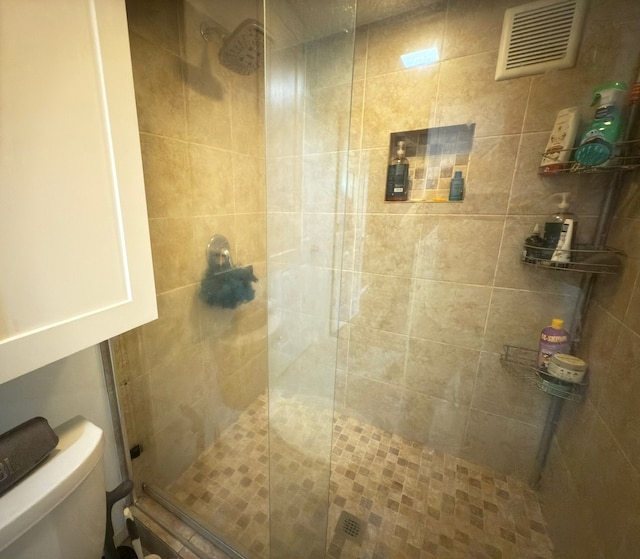 bathroom with a shower stall and toilet