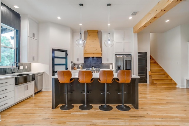 1014 Eagles Ridge Ct, Weatherford, TX 76087 - kitchen featuring stainless steel appliances, custom exhaust hood, light wood-type flooring, white cabinetry, and recessed lighting