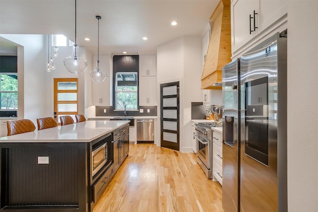1014 Eagles Ridge Ct, Weatherford, TX 76087 - kitchen with appliances with stainless steel finishes, light wood-style flooring, tasteful backsplash, light countertops, and white cabinets