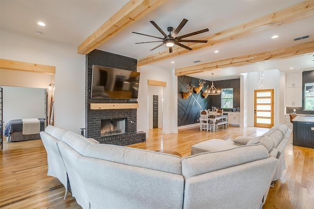 1014 Eagles Ridge Ct, Weatherford, TX 76087 - living room with beam ceiling, wood finished floors, a ceiling fan, a brick fireplace, and plenty of natural light
