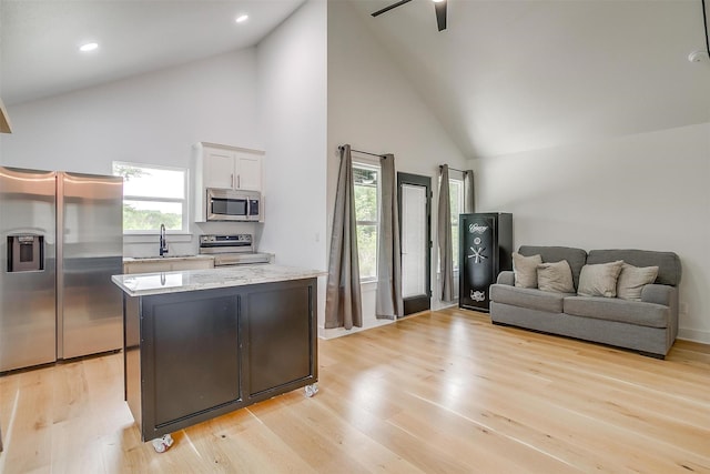 1014 Eagles Ridge Ct, Weatherford, TX 76087 - kitchen with appliances with stainless steel finishes, high vaulted ceiling, a sink, white cabinets, and ceiling fan