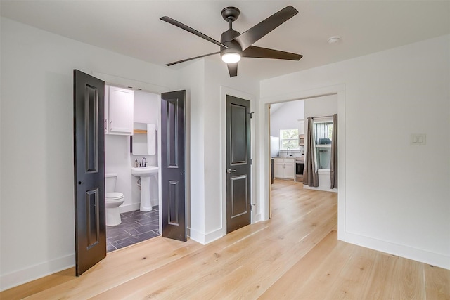 1014 Eagles Ridge Ct, Weatherford, TX 76087 - unfurnished bedroom with light wood-style flooring, baseboards, ensuite bath, and a sink