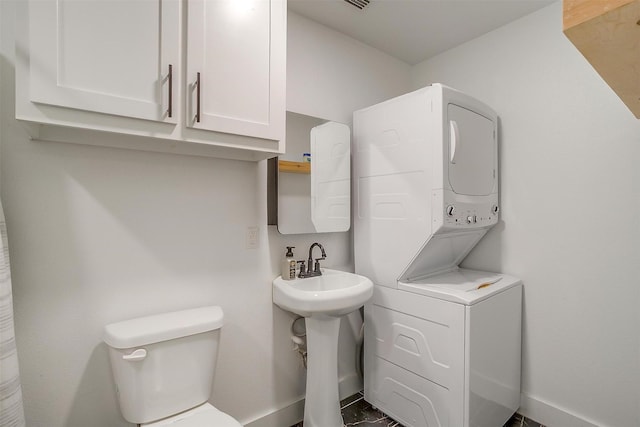 1014 Eagles Ridge Ct, Weatherford, TX 76087 - bathroom with estacked washer and dryer, toilet, and baseboards