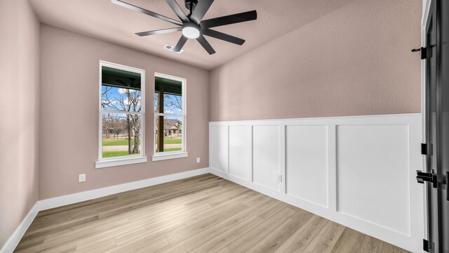 ZEPHYR2TBD Eagles Ridge Dr, Brock, TX 76087 - empty room featuring light wood-style flooring, a ceiling fan, and a wainscoted wall
