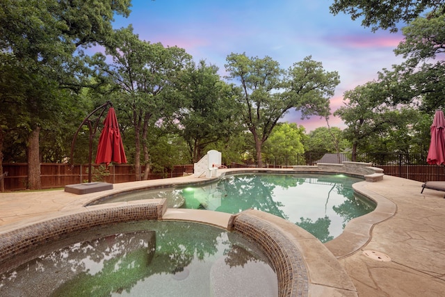7313 Jo Will St, Colleyville, TX 76034 - pool at dusk with a pool with connected hot tub, a fenced backyard, and a patio