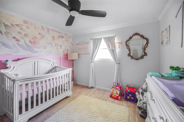 304 Moore St, Jacksboro, TX 76458 - bedroom with ornamental molding, a nursery area, wood finished floors, ceiling fan, and baseboards