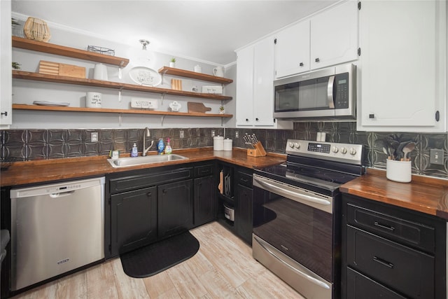 304 Moore St, Jacksboro, TX 76458 - kitchen with appliances with stainless steel finishes, a sink, white cabinets, wood counters, and ornamental molding