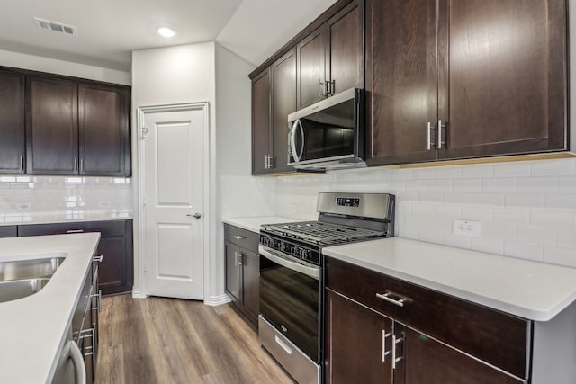 968 Linden Ct, Lavon, TX 75166 - kitchen with appliances with stainless steel finishes, dark wood-style floors, backsplash, dark brown cabinetry, and recessed lighting