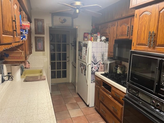909 Mckinney Ave, Princeton, TX 75407 - kitchen with black appliances, a sink, a ceiling fan, and brown cabinets