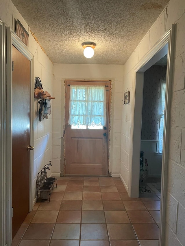 909 Mckinney Ave, Princeton, TX 75407 - doorway featuring a textured ceiling and tile patterned flooring