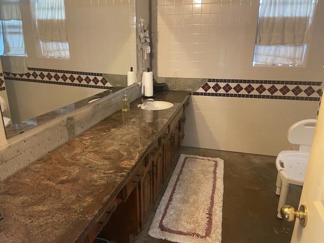 909 Mckinney Ave, Princeton, TX 75407 - bathroom featuring vanity, toilet, tile walls, and concrete floors