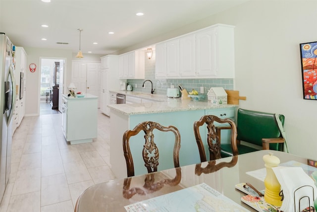 305 Brookview Dr, Decatur, TX 76234 - kitchen featuring decorative backsplash, stainless steel appliances, a sink, a kitchen island, and white cabinetry