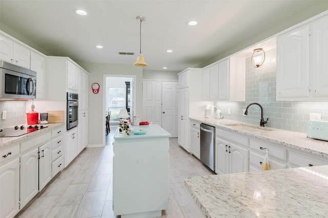 305 Brookview Dr, Decatur, TX 76234 - kitchen featuring a sink, stainless steel appliances, a kitchen island, tasteful backsplash, and white cabinetry