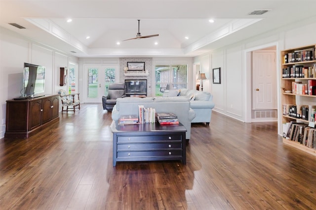 305 Brookview Dr, Decatur, TX 76234 - living room featuring a raised ceiling, a ceiling fan, crown molding, dark wood-type flooring, and a brick fireplace