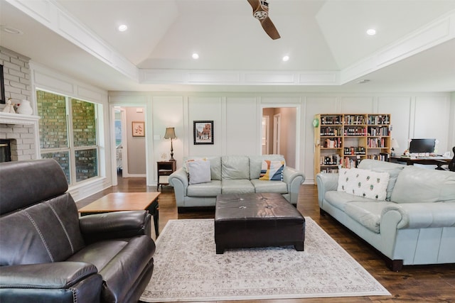 305 Brookview Dr, Decatur, TX 76234 - living room featuring vaulted ceiling, a decorative wall, dark wood-type flooring, a ceiling fan, and a brick fireplace