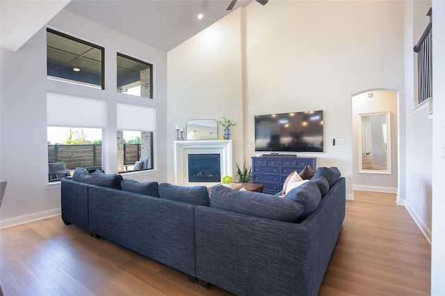 2708 Darlington Rd, Northlake, TX 76226 - living area with a high ceiling, wood finished floors, baseboards, a glass covered fireplace, and ceiling fan