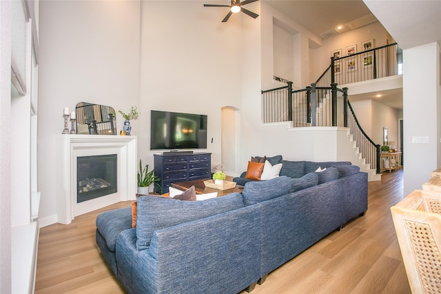2708 Darlington Rd, Northlake, TX 76226 - living area featuring a towering ceiling, stairs, wood finished floors, a ceiling fan, and arched walkways