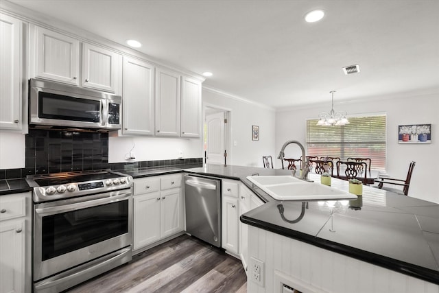 200 Oakview Cir, Mexia, TX 76667 - kitchen with appliances with stainless steel finishes, dark countertops, crown molding, a chandelier, and white cabinetry
