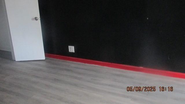 spare room featuring wood finished floors and baseboards