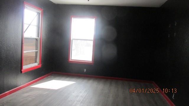 spare room featuring wood finished floors and baseboards