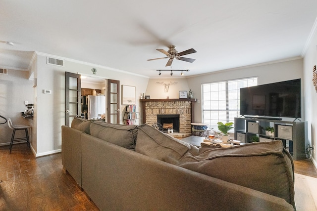 4800 Northway Dr Unit 17A, Dallas, TX 75206 - living room with dark wood-style flooring, crown molding, a ceiling fan, a brick fireplace, and baseboards