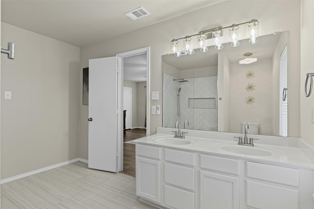 8537 Gray Shale Dr, Fort Worth, TX 76179 - bathroom featuring tiled shower, double vanity, and baseboards