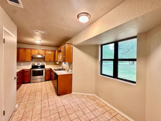 677 County Road 3081, Lampasas, TX 76550 - kitchen with stainless steel range with electric cooktop, light countertops, a textured ceiling, light tile patterned floors, and a sink